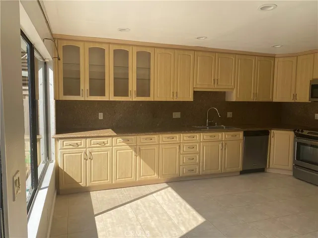 a kitchen with granite countertop a sink and cabinets
