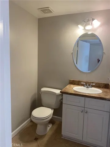 a bathroom with a toilet sink vanity and mirror