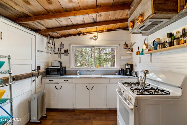 a kitchen with a refrigerator a sink and wooden floors