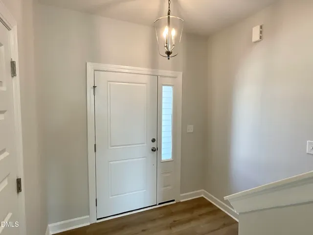 a view of entryway and gallery with wooden floor