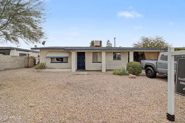 a view of a house with a patio and a yard