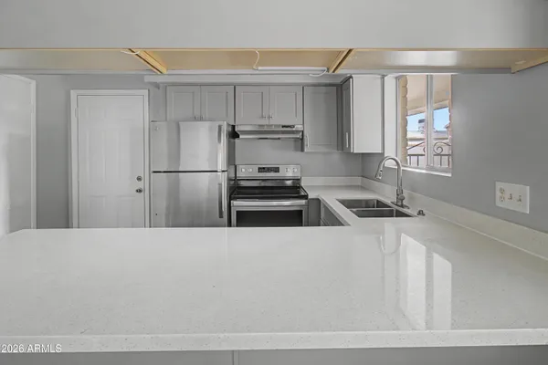 a kitchen with a refrigerator sink and cabinets