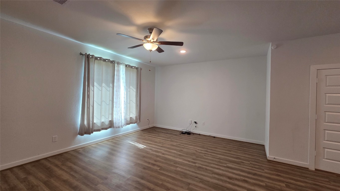 1015 Thor Roman Forest, TX 77357 - Photo 6 of 15 an empty room with wooden floor fan and windows