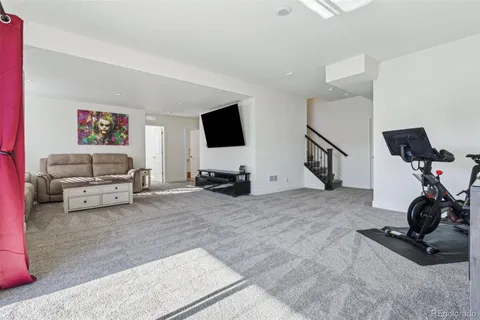 a living room with furniture a flat screen tv and kitchen view