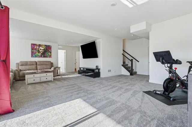a living room with furniture a flat screen tv and kitchen view