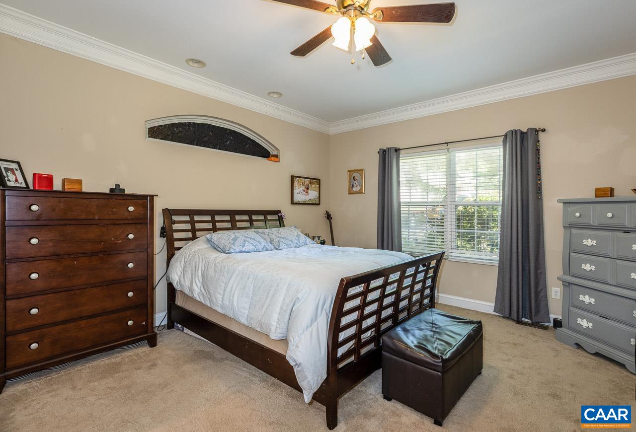 5 Tanglewood Road Palmyra, VA 22963 - Photo 11 of 17 a bedroom with a bed and a chandelier