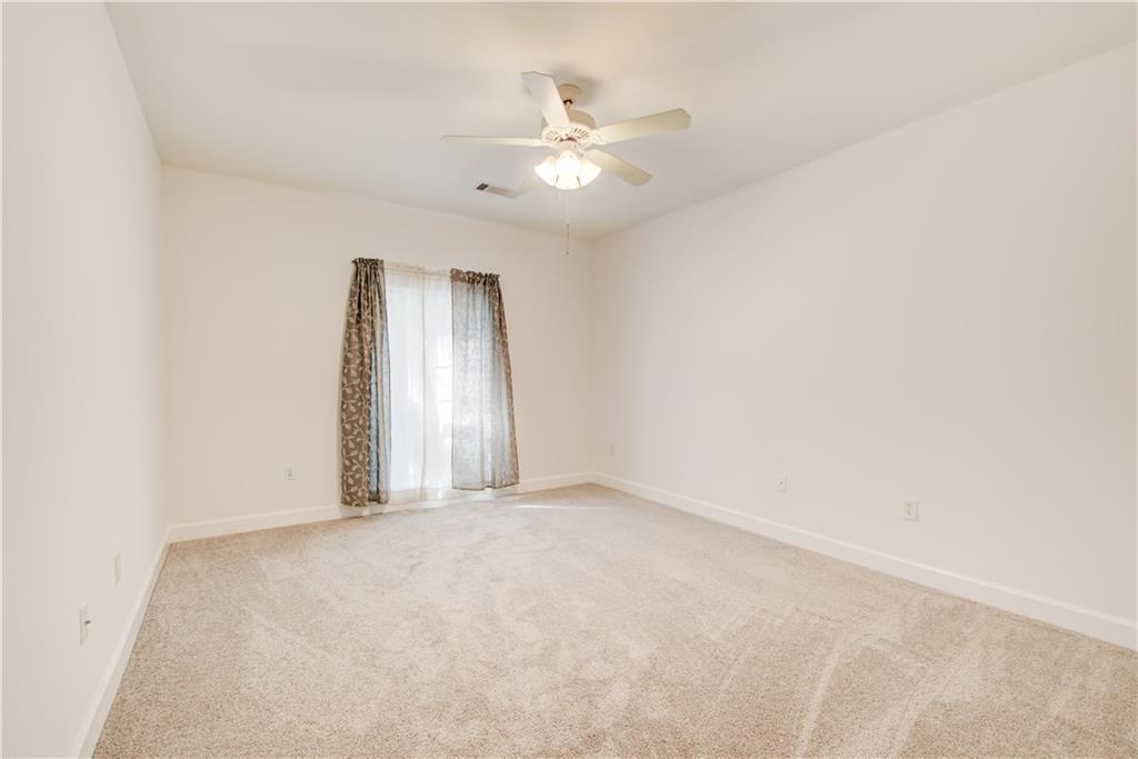 2865 Lenox Road Northeast, Unit 102 Atlanta, GA 30324 - Photo 20 of 35 an empty room with a chandelier fan and windows