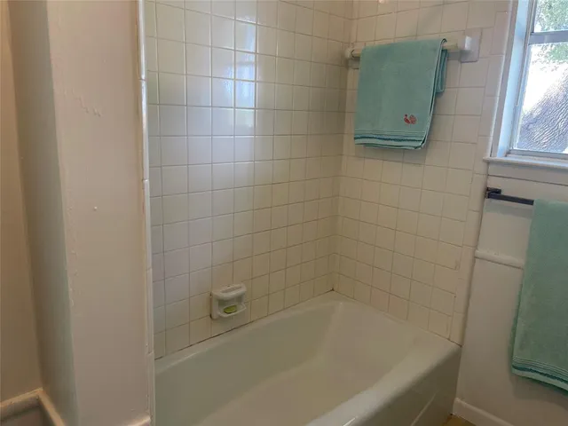 a bathroom with a granite countertop sink and a bathtub