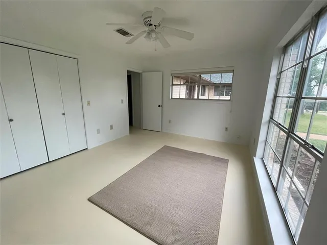 a bathroom with a granite countertop sink a toilet a mirror and window