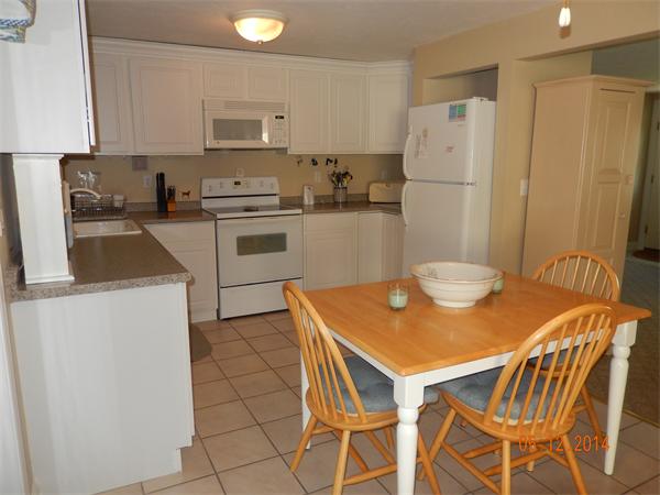 672 County Road Barrington, RI 02806 - Photo 4 of 13 a kitchen with a table chairs and a refrigerator