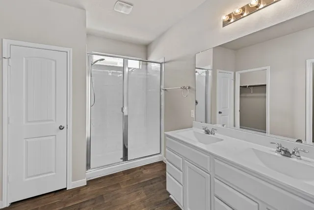 a bathroom with double vanity sinks and a mirror