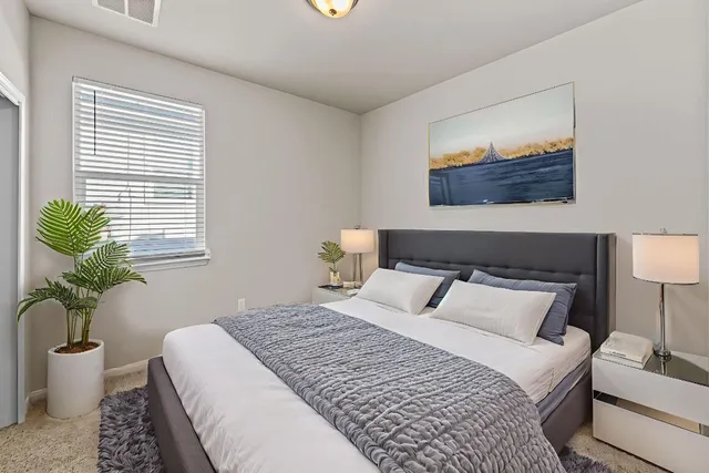 a bedroom with a bed and a painting on the wall