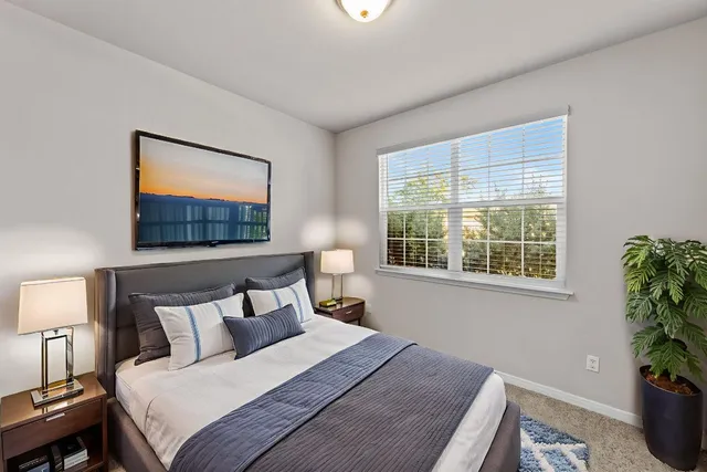 a bedroom with a bed and a potted plant