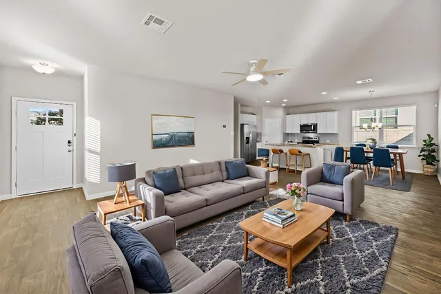 a living room with furniture a couch and kitchen view