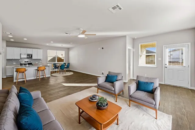 a living room with furniture and kitchen view
