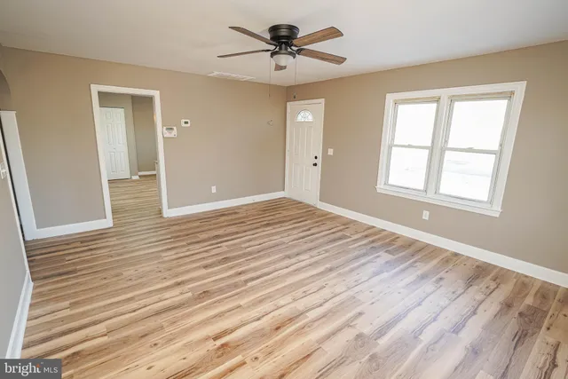 a view of a room with wooden floor and ceiling fan