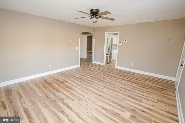 a view of a room with wooden floor and ceiling fan
