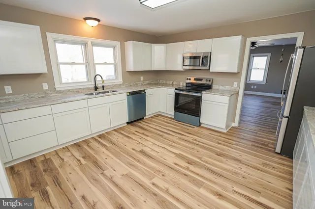 a kitchen with granite countertop white cabinets and white appliances