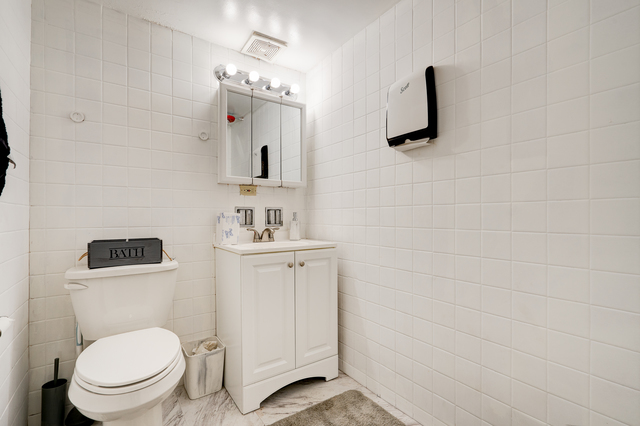 6905 Cermak Road Berwyn, IL 60402 - Photo 7 of 29 a bathroom with a toilet sink and mirror