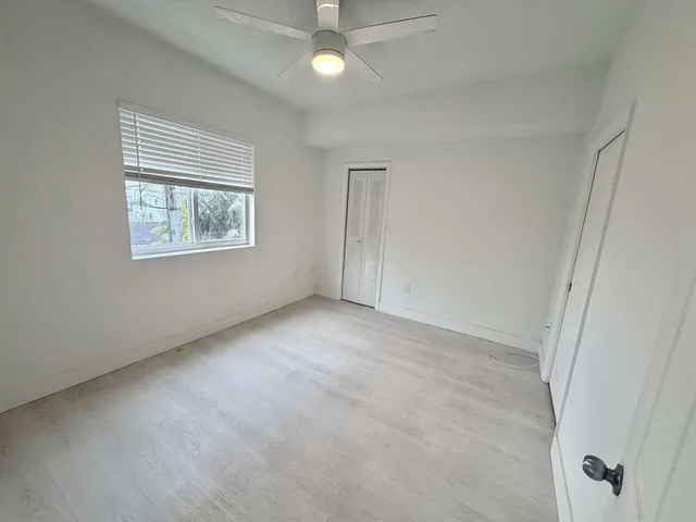 an empty room with windows and closet