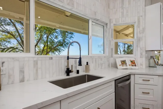 a kitchen with a sink a counter top space stainless steel appliances and cabinets