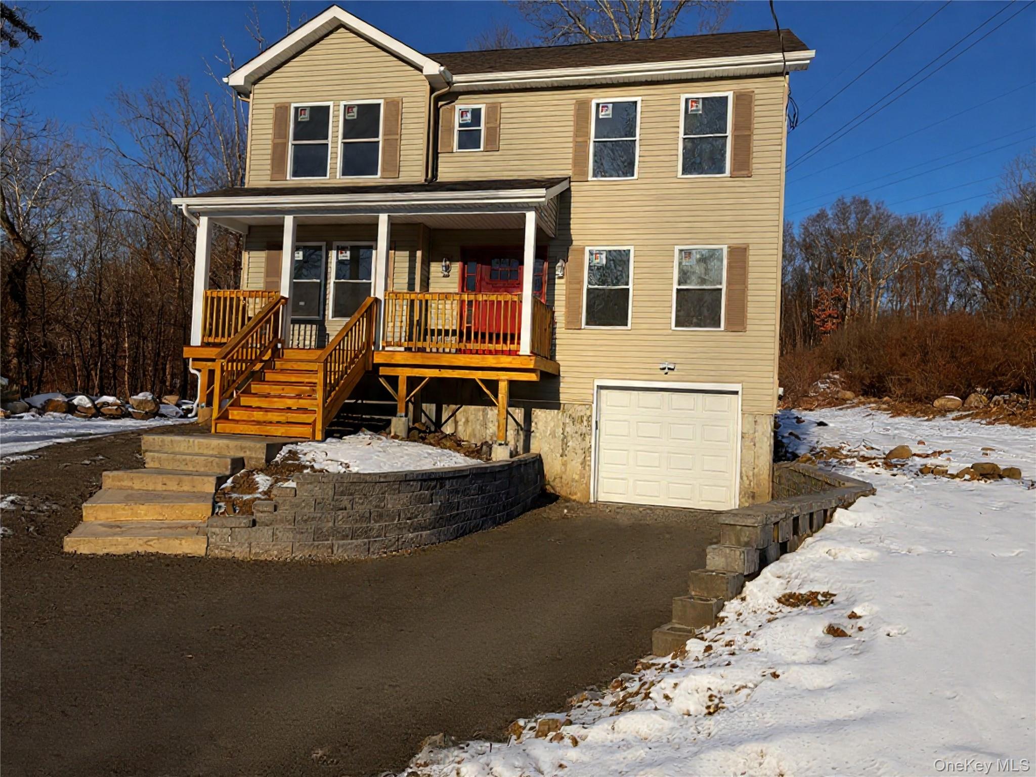 View of front of property with covered porch and an attached garage