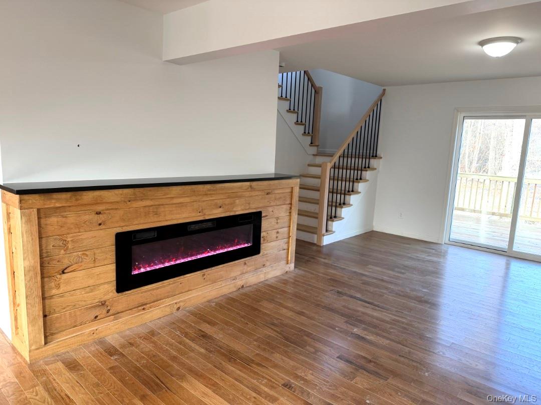 458 County Route 50 New Hampton, NY 10958 - Photo 4 of 35 an empty room with wooden floor fireplace and windows