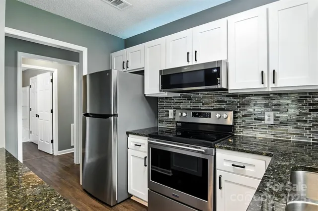 a kitchen with stainless steel appliances a stove microwave and refrigerator