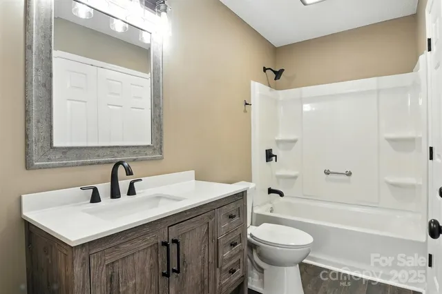 a bathroom with a sink toilet vanity and shower