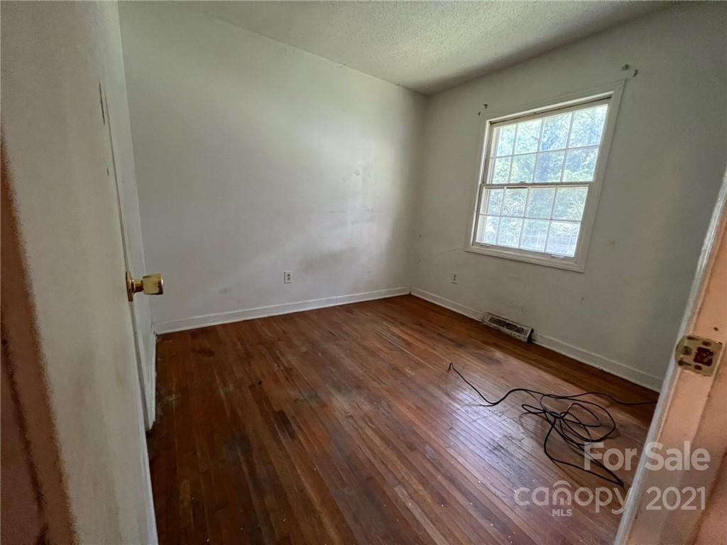 1018 Tilden Road Charlotte, NC 28214 - Photo 11 of 17 an empty room with wooden floor and windows
