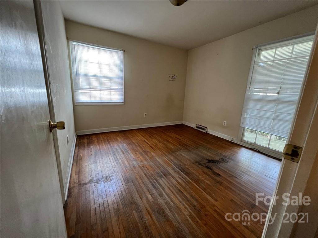 1018 Tilden Road Charlotte, NC 28214 - Photo 12 of 17 an empty room with wooden floor and windows