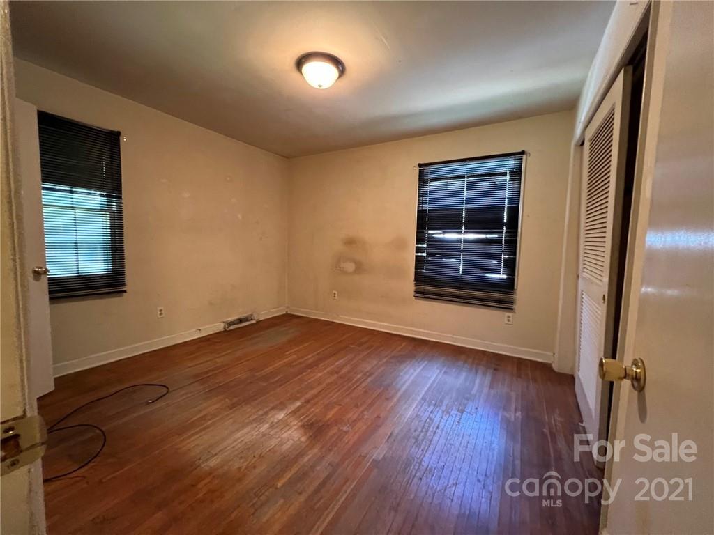 1018 Tilden Road Charlotte, NC 28214 - Photo 13 of 17 an empty room with wooden floor closet and windows