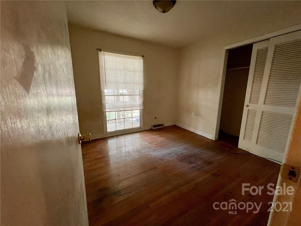 1018 Tilden Road Charlotte, NC 28214 - Photo 14 of 17 an empty room with wooden floor and windows