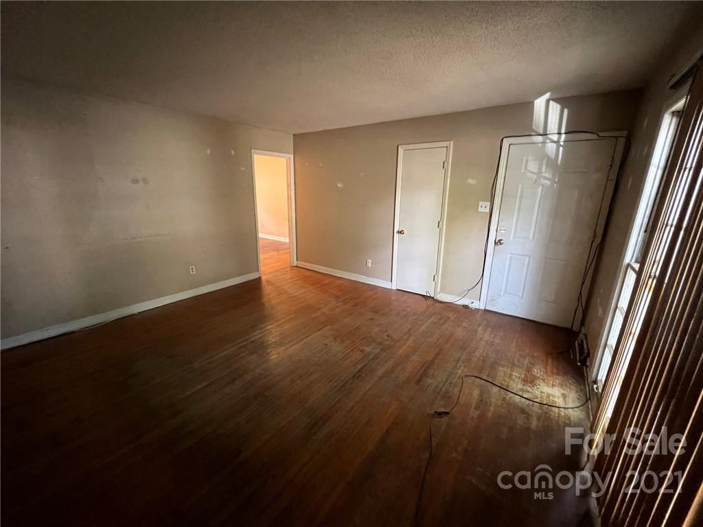 1018 Tilden Road Charlotte, NC 28214 - Photo 4 of 17 an empty room with wooden floor and windows