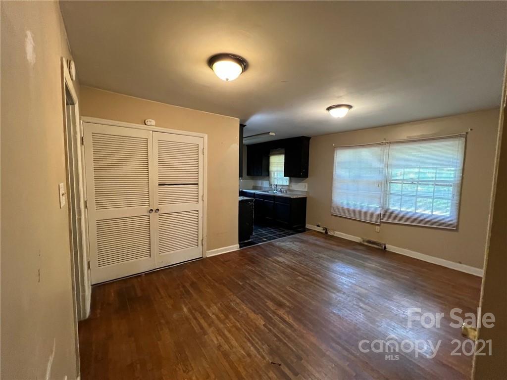1018 Tilden Road Charlotte, NC 28214 - Photo 6 of 17 an empty room with wooden floor cabinet and windows