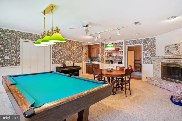 a room with pool table chairs and windows