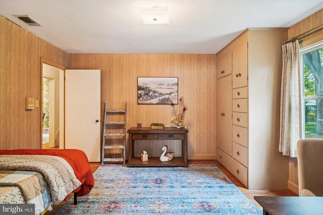 a bedroom with a bed and wooden floor