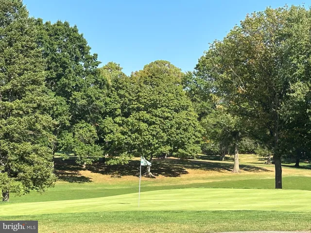 a roof deck with table and chairs with wooden fence