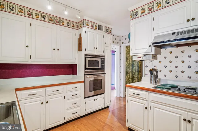 a kitchen with white cabinets and appliances