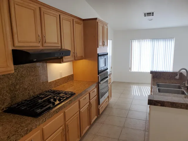 a kitchen with granite countertop a stove and a refrigerator