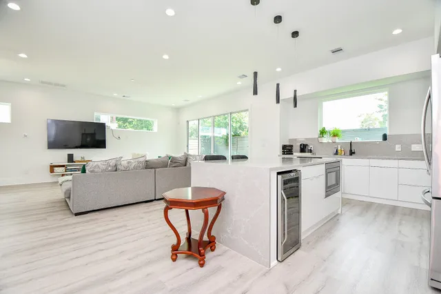 a kitchen with white cabinets and black stainless steel appliances