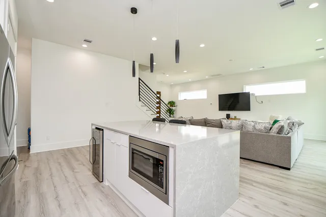 a view of kitchen with microwave stove refrigerator and couches