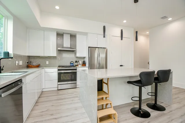 a kitchen with granite countertop a counter space a sink stainless steel appliances and cabinets