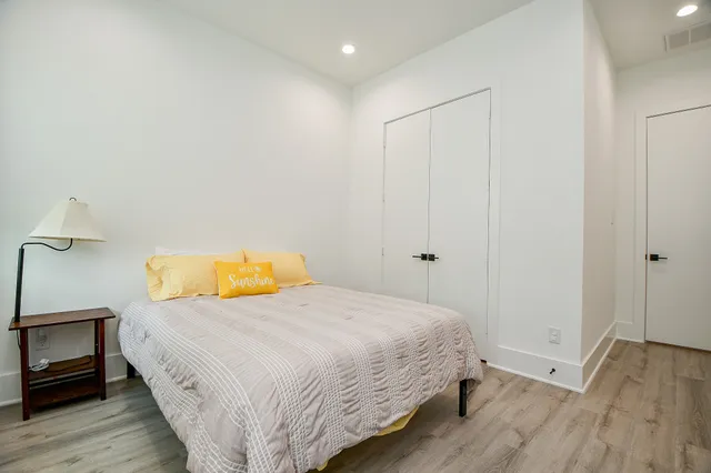 a bedroom with a bed and wooden floor
