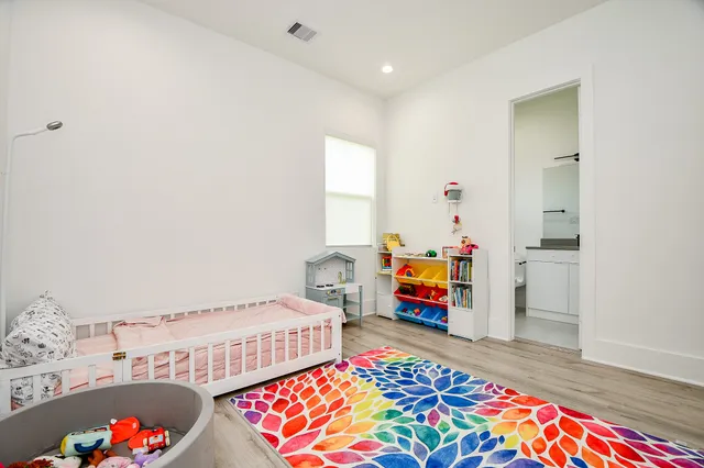 a bedroom with bed and a wooden floor