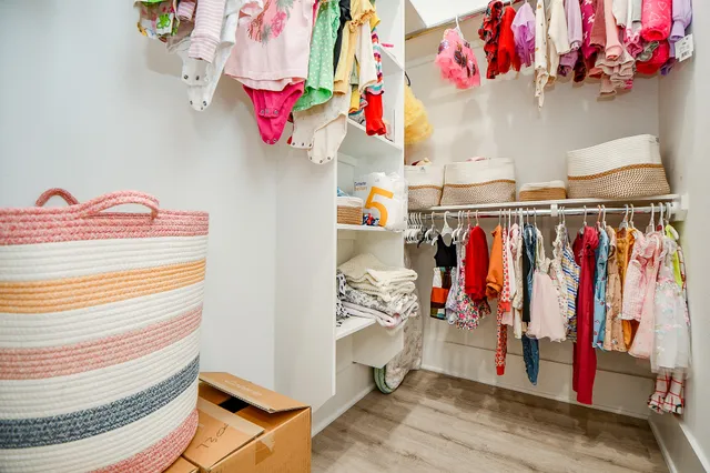 a view of walk in closet with clothes