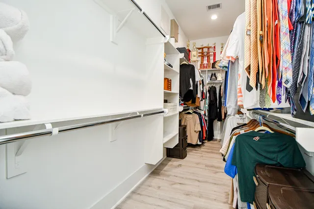 a view of walk in closet with clothes and shoes