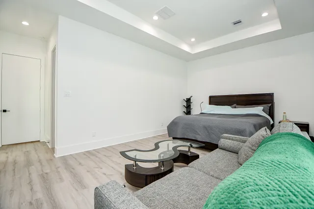 a bedroom with a bed and wooden floor