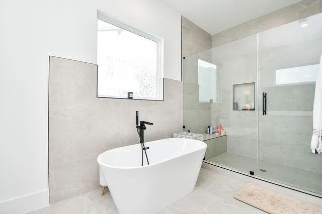 a white bath tub sitting next to a bathroom sink