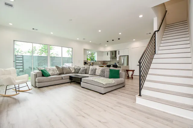 a living room with furniture and hard wood flooring